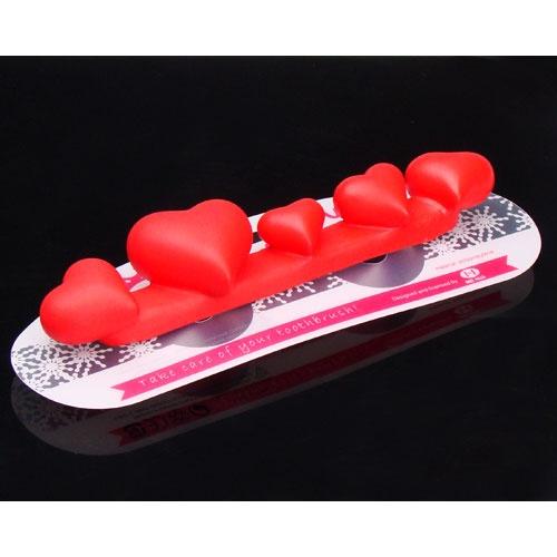 Foto cinco con cepillo de dientes titular corazón de succión de pared
