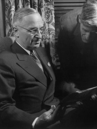 Foto Lámina fotográfica de primera calidad US President Harry S. Truman Reviewing Photographs with His Press Secretary Charles Ross de Gjon Mili, 61x46 in.
