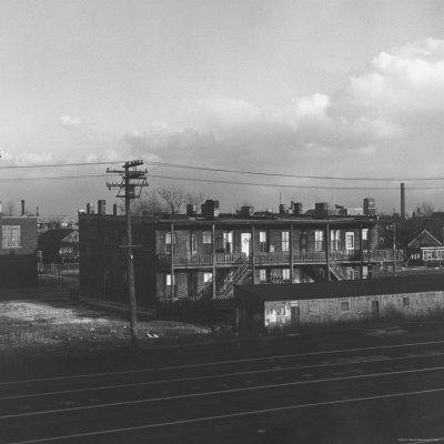 Foto Lámina fotográfica Landscape View of Ugly Backs of Houses and Buildings as Seen from Train Window de Walker Evans, 41x41 in.