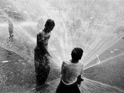 Foto Lámina fotográfica Children Playing in the Spray of an Open Fire Hydrant to Escape the Ongoing Heat Wave de Peter Stackpole, 41x30 in. foto 790322