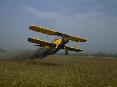 Foto Lámina fotográfica Crop Duster Soars Low to the Ground to Spray a Cotton Field de Joseph Baylor Roberts, 41x30 in. foto 747017