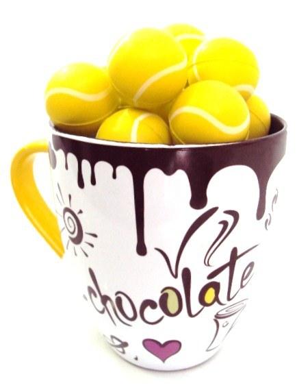 Foto Pelotas de tenis de chocolate y taza de cerámica 